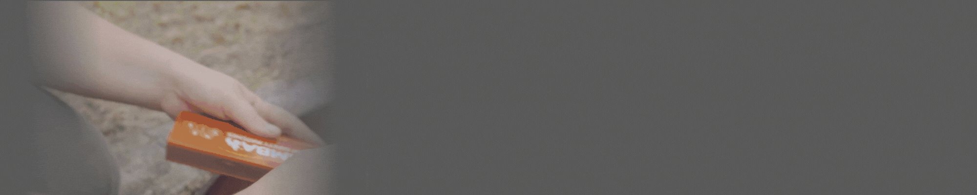 An outstretch hand lights a match to start a campfire. They move back a camp chair that is too close to the fire. 